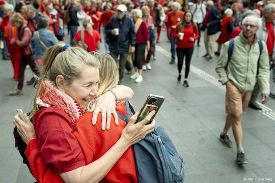 Drukte op stations met in het rood geklede demonstranten